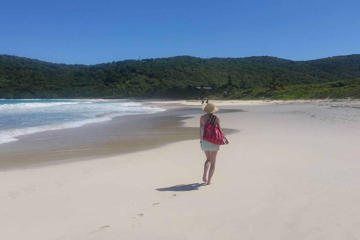 Girl walking on Flamenco Beach in Culebra on a sunny day