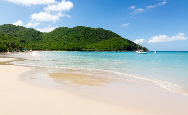 Empty Anse Marcel beach and green hills in St. Martin